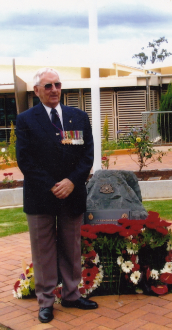 Allan Guy standing in front of war memorial.